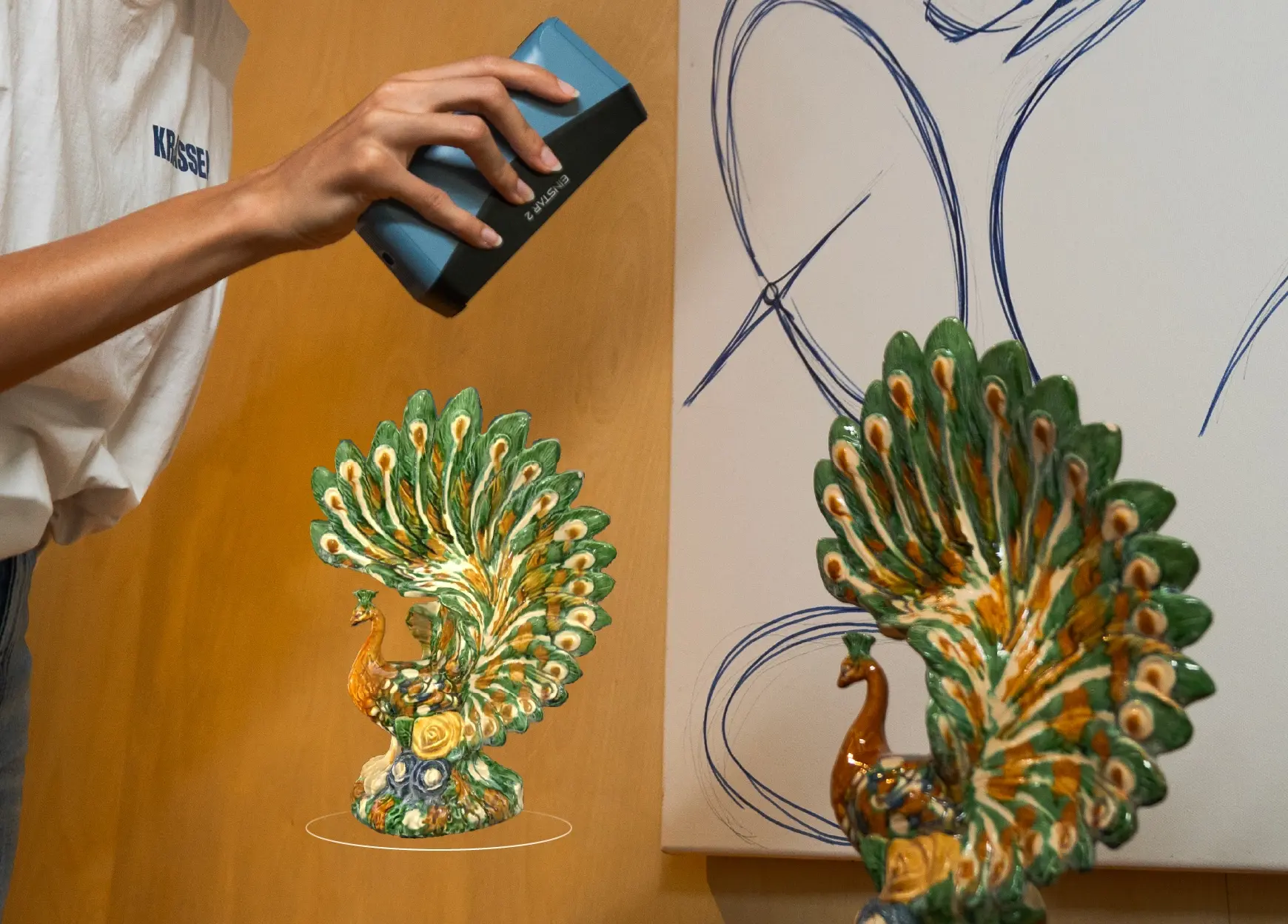 EINSTAR 2 scanning a colourful peacock sculpture indoors, demonstrating detailed full-colour texture capture.