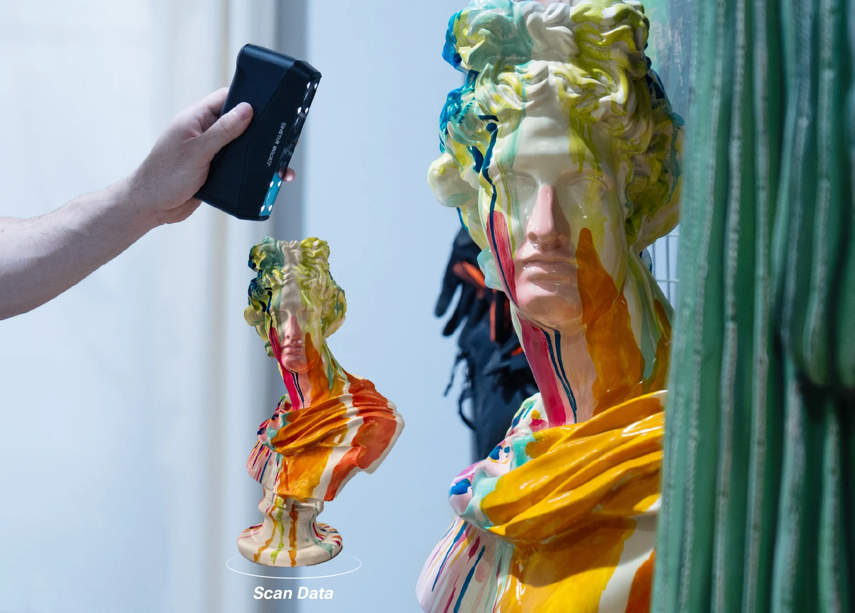 EINSTAR Rockit scanning a colourful ceramic bust, with the 3D scan data displayed beside the original sculpture.