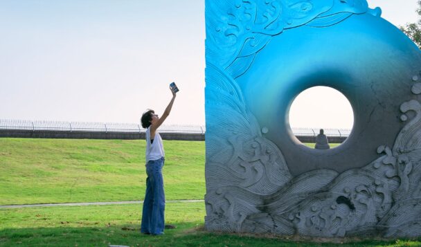 Designer using the EINSTAR 2 handheld 3D scanner to capture a large outdoor sculpture.